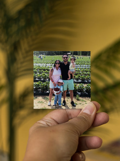 Custom square photo 3x3 magnet of a family photo held by a hand with a blurred background.